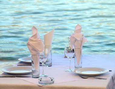 Deniz kenarındaki restoranda bir masa, öğle yemeği için ayarlandı.