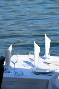 Deniz kenarındaki restoranda bir masa, öğle yemeği için ayarlandı.
