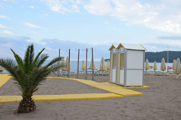 海滩设备 木板人行道 流动厕所 雨伞和甲板椅 免版税图库图片