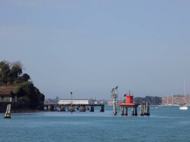 Venedik, İtalya - 8 Nisan 2018: Kanalın her iki tarafındaki gondolları bağlamak için tahta direkler