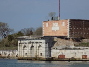 Venedik, İtalya - 8 Nisan 2018: Kanalın her iki tarafındaki gondolları bağlamak için tahta direkler