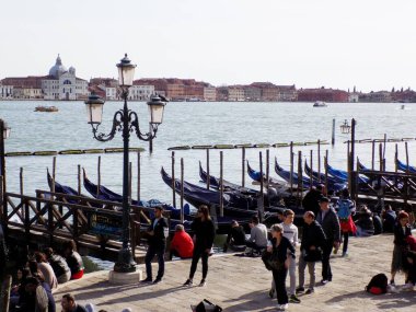 Venedik, İtalya - 8 Nisan 2018: Fermata Vaporetto San Zaccaria 'daki turistler, gondollar ve Venedik Limanı' ndaki küçük tekneler için demirliyorlar.