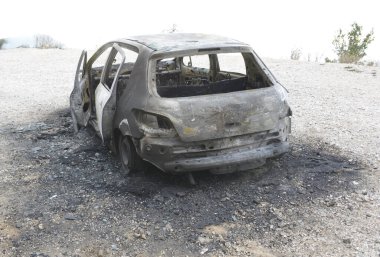 Araba kazasından sonra yolun kenarındaki otoparkta yanmış.