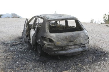 Araba kazasından sonra yolun kenarındaki otoparkta yanmış.