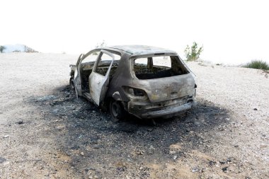 Araba kazasından sonra yolun kenarındaki otoparkta yanmış.