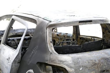 Araba kazasından sonra yolun kenarındaki otoparkta yanmış.