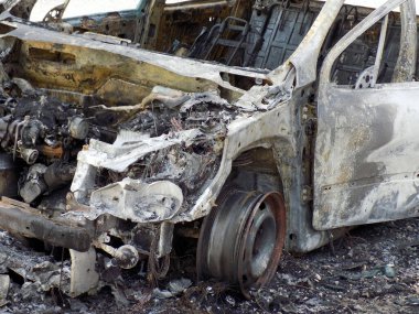 Araba kazasından sonra yolun kenarındaki otoparkta yanmış.