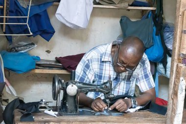 Mtowambu, Tanzanya - 12 Ekim 2022: Tanzanya 'nın Mtowanbu kasabasında bir pazar yerinde çalışan bir terzi.