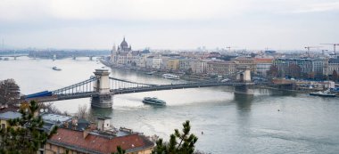 Macaristan 'ın Budapeşte kentinden geçen Tuna Nehri' nin panoramik bir manzarası, bulutlu bir kış gününde.