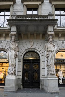 Budapeşte, Macaristan - 28 Kasım 2022: Budapeşte, Macaristan 'da bir sokak girişinde iki heykel ve süslü bir metal kapı.