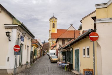 Szentendre, Macaristan - 30 Kasım 2022: Bulutlu bir kış gününde, Macar köyü Szentendre 'de saat kulesi olan tipik bir cadde.