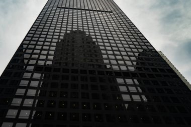 New York şehrindeki gökdelenler bulutlu bir günde başka bir gökdelenin camlarına yansıyor..
