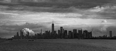 Bulutlu bir günde, denizden bakıldığı gibi Manhattan siluetinin siyah beyaz bir görüntüsü..