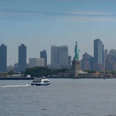 New York, ABD - 21 Temmuz 2023: Sisli bir günde Özgürlük Heykeli 'ne giden bir turist feribotu.