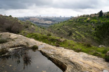 Eski bir adam, fırtınalı ve puslu bir kış gününde İsrail 'in Kudüs yakınlarındaki Judea dağlarında kayalara oyulmuş su kuyusu kazdı..