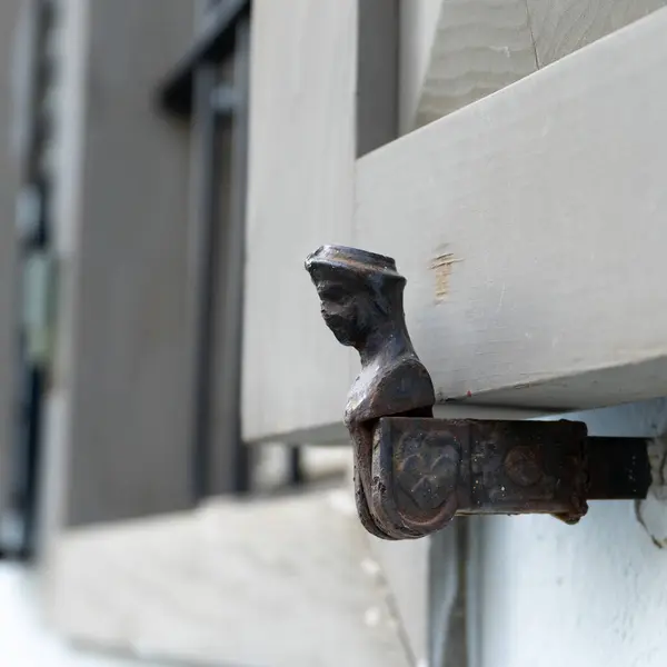 stock image A typical old fashioned window shutter holder in an old building in Tel Aviv, Israel. It is made of metal, and designed like a little man.