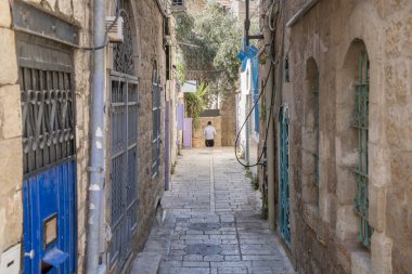 İsrail, Kudüs 'ün eski mahallelerinde tipik bir ara sokak. Taş evler, kaldırımlar ve tüm pencere ve kapılarında renkli metal parmaklıklar var..