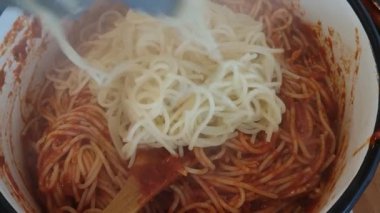 Romen bir kadın domates soslu spagetti hazırlıyor