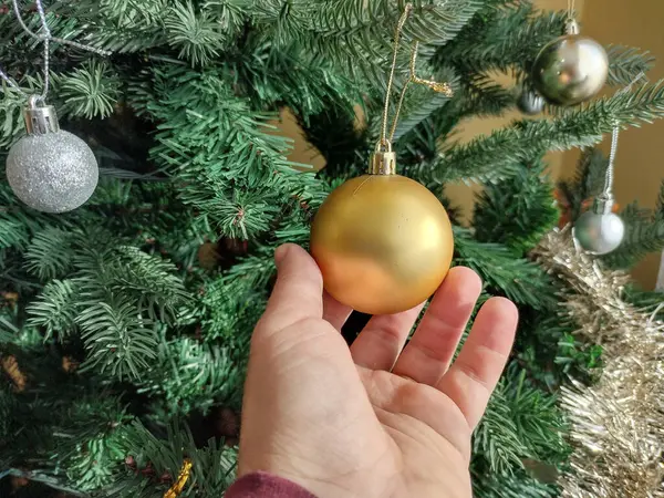 Человек Касается Золотого Глобуса Рождественской Елке — стоковое фото