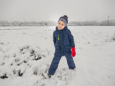 Romanyalı bir çocuk karda kışın tadını çıkarıyor