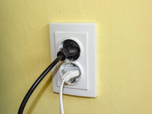 A black plug and a white plug in the socket