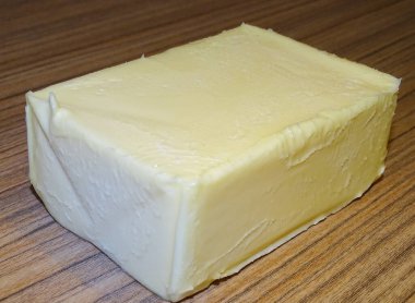 Ahşap arka planda organik inek sütü yağı.