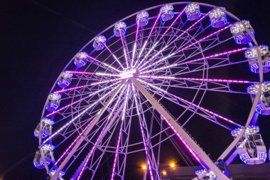 Gece boyunca kamarası ve ışıkları olan büyük dönme dolap. Romanya 'da