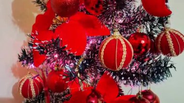 Kırmızı süslemelerle süslenmiş küçük bir Noel ağacının videosu. 4K