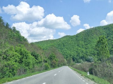 Yol ve ileride yeşil bir tepe var. Romanya 'da