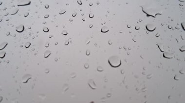Penceresinde yağmur damlaları olan bir video. Yağmur yağıyor.