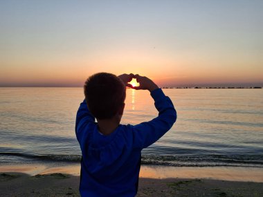 Bir çocuk ve güneş Karadeniz 'in üzerinde doğuyor. Mamaia 'da, Constanta