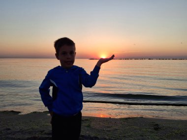 Bir çocuk ve güneş Karadeniz 'in üzerinde doğuyor. Mamaia 'da, Constanta