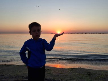 Bir çocuk ve güneş Karadeniz 'in üzerinde doğuyor. Mamaia 'da, Constanta