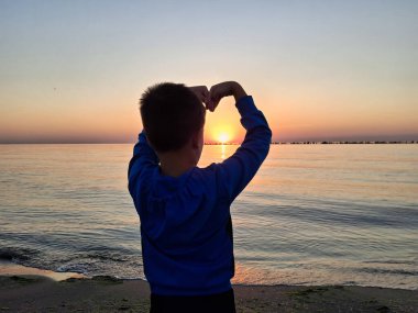 Bir çocuk ve güneş Karadeniz 'in üzerinde doğuyor. Mamaia 'da, Constanta