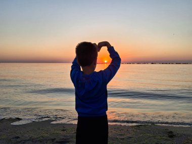 Bir çocuk ve güneş Karadeniz 'in üzerinde doğuyor. Mamaia 'da, Constanta