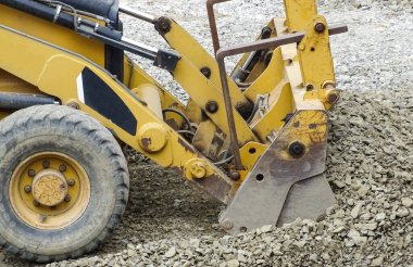 Bir kepçe doldurucu bir taş yığınıyla çalışır.