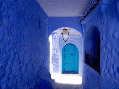 Blue-walled passageway with door, Chefchaouen, the blue city, Morocco. High quality photo clipart