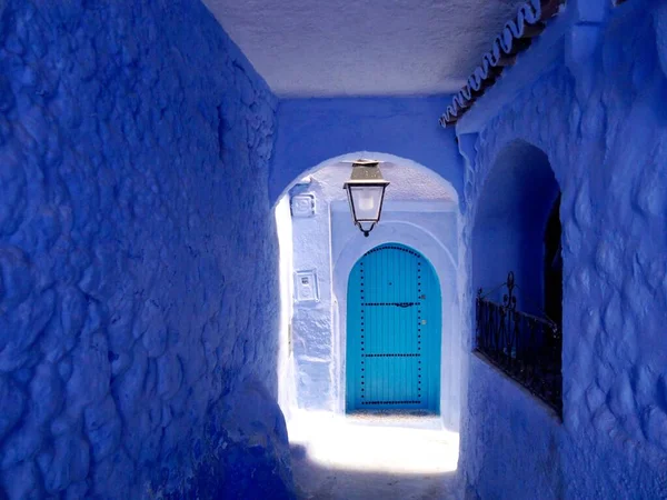 Blue-walled passageway with door, Chefchaouen, the blue city, Morocco. High quality photo