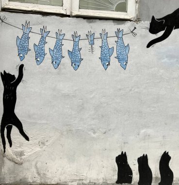 Batumi, Georgia 'da sokak sanatı üzerine ilginç bir kara kedi ve balık. Yüksek kalite fotoğraf