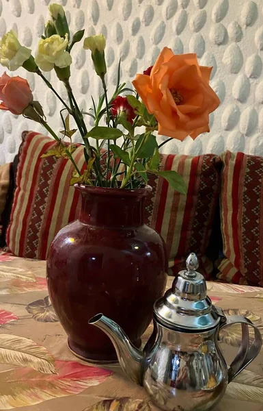 Traditional teapot and roses on table in restaurant, Essaouira, Morocco. High quality photo