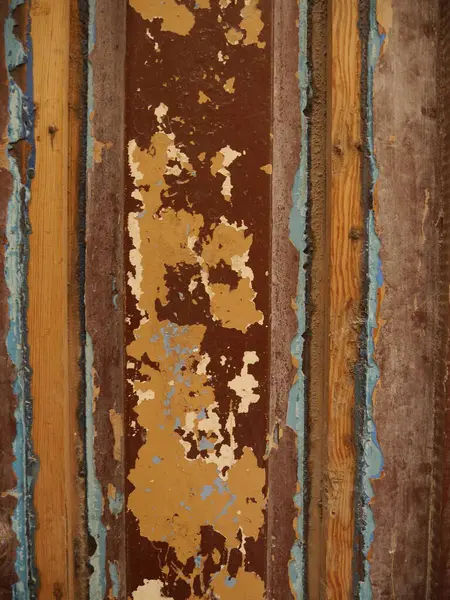 stock image Textured background or backdrop of weathered rustic wood with dark red, orange and light blue paint peeling off as background