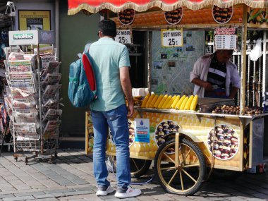 İstanbul, Türkiye 'de sokak tezgahında mısır alan genç bir adam. Yüksek kalite fotoğraf