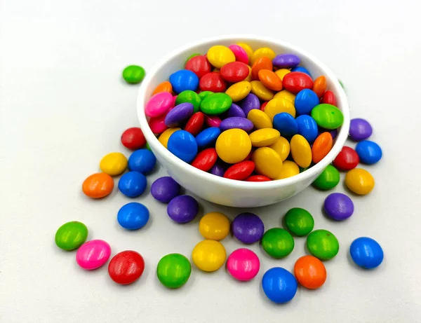 Colorful candies in a bowl isolated on a white background.