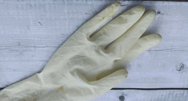 Rubber gloves on a white wooden background. The concept of protection against viruses.