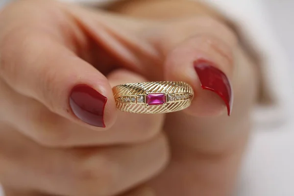 紧贴着一只手拿着钻石戒指的女子的手 — 图库照片