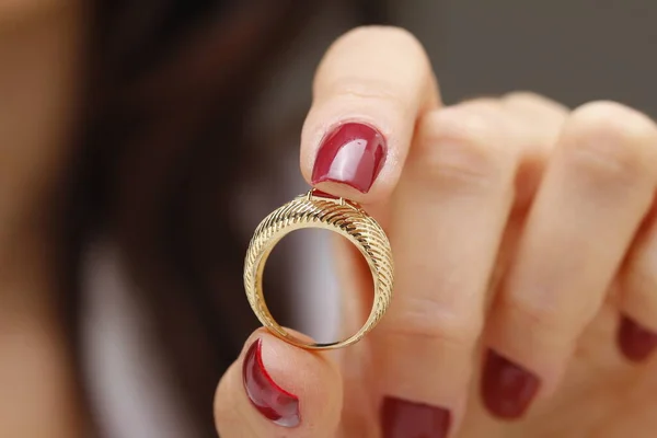 close-up of a female hand with a gold ring on a white background