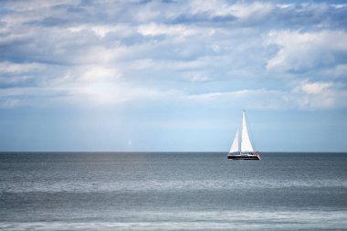 Denizde bir tekne. Denizde beyaz yelkenli lüks bir yatta yelken açmak.