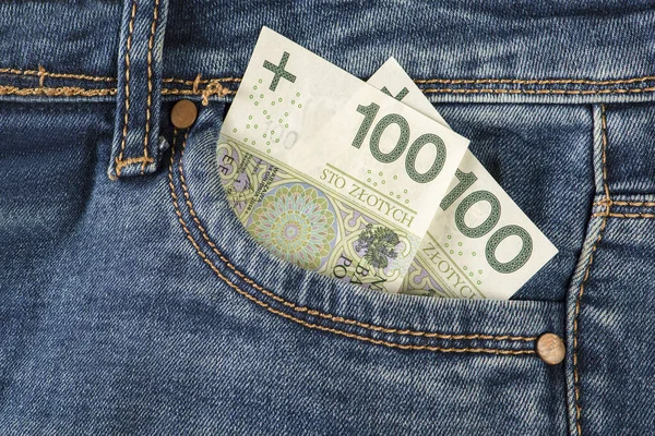 Kot pantolonun cebinde 100 zloti banknot. Para kotun ön cebinde. Yatırım, para, servet ve kar kavramı, telif hakkı