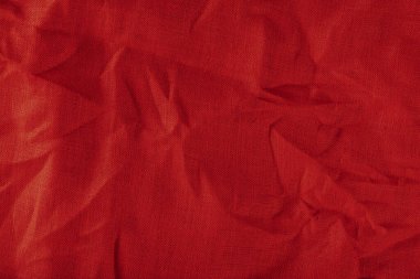 Kırmızı keten kumaş. Buruşmuş keten kumaş dokusu yakın plan katlanmış.