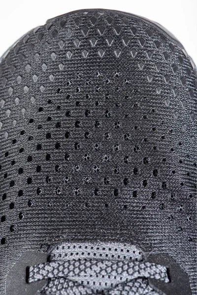 Mesh fabric of sports shoes in gray color. Shoes made of mesh fabric with a textile texture, for an active lifestyle, running and sports. Modern running shoes close-up